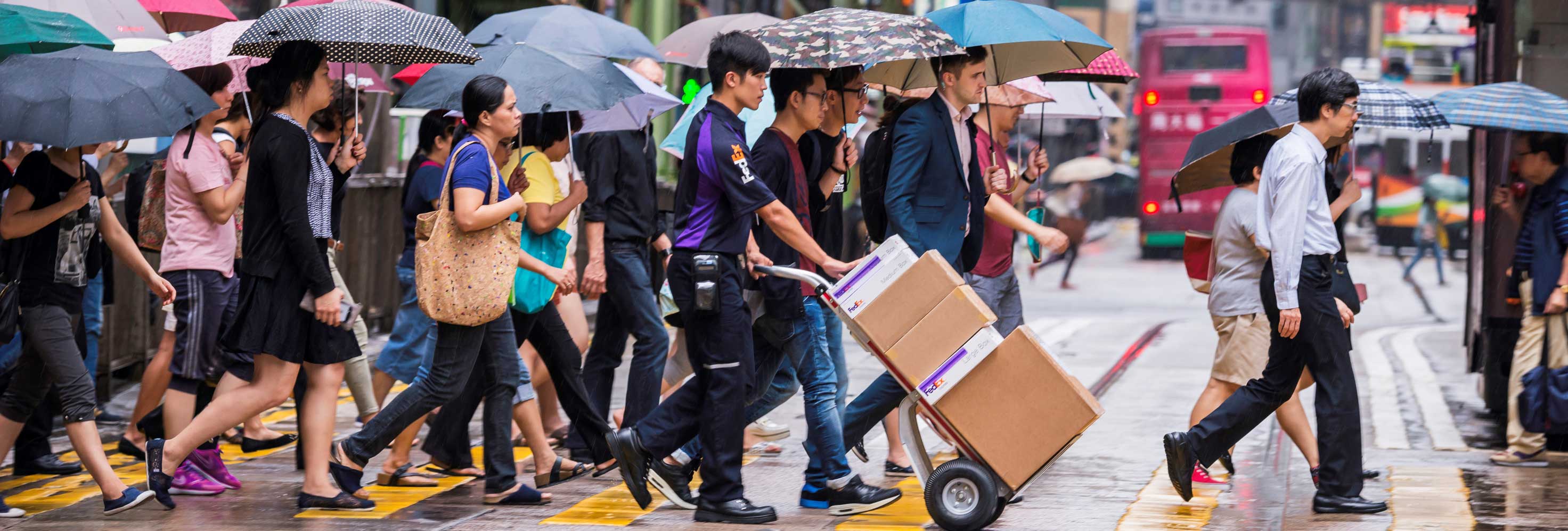 FedEx worker moving packages with a hand truck