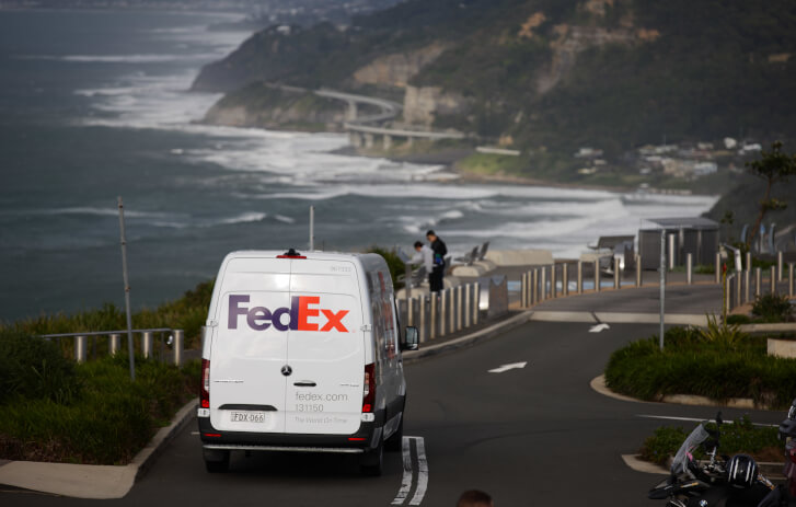 FedEx truck driving on a road near a beach