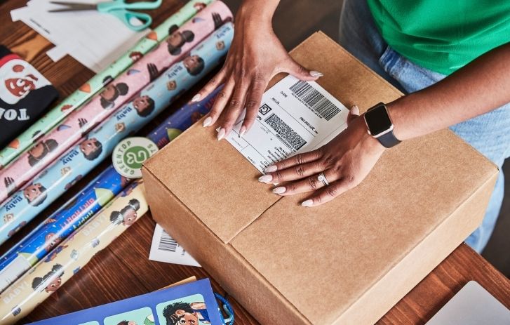 Eine Frau klebt ein Etikett auf ein Paket