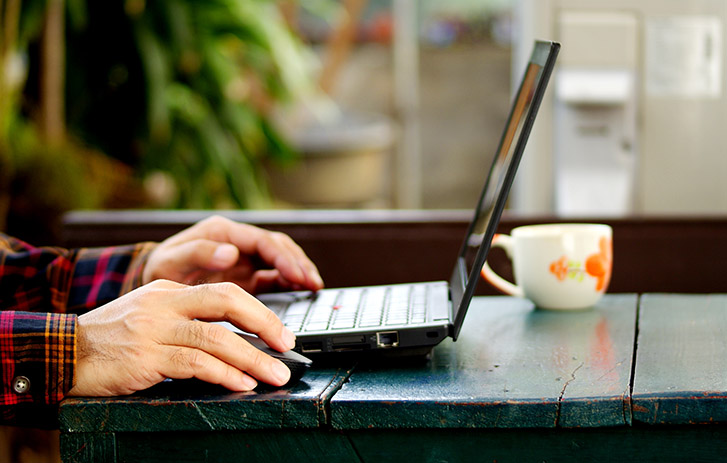 Hands typing at a laptop