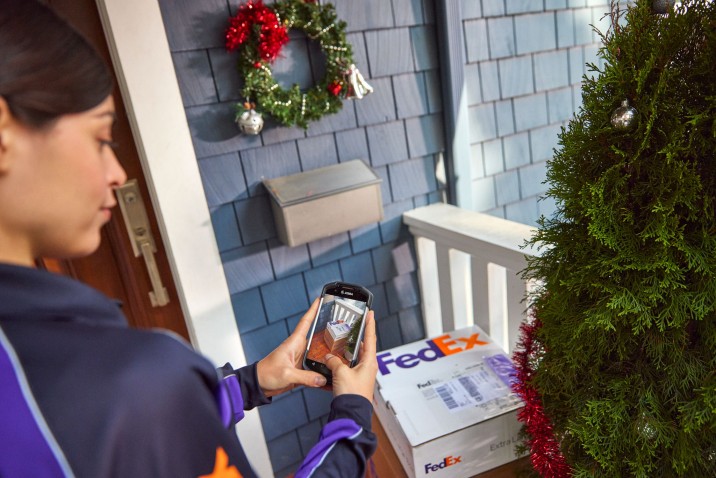 FedEx courier capturing a picture as proof of delivery.