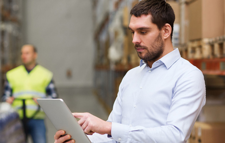 man on a tablet in a warehouse