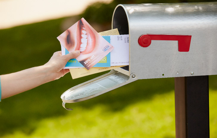 person taking mail out of a mailbox