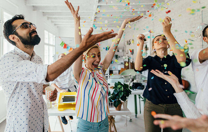 Employees celebrate with confetti in office