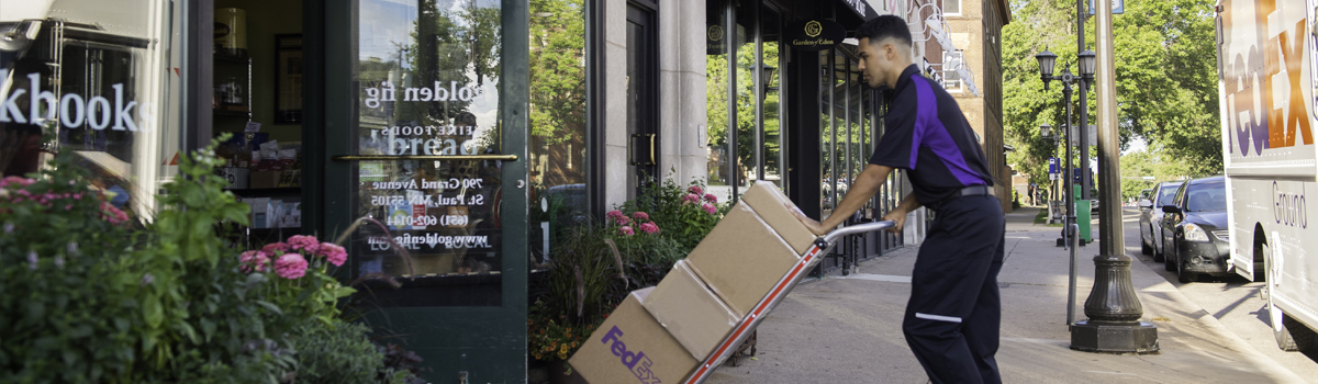 fedex employee safely pulling pallet of packages