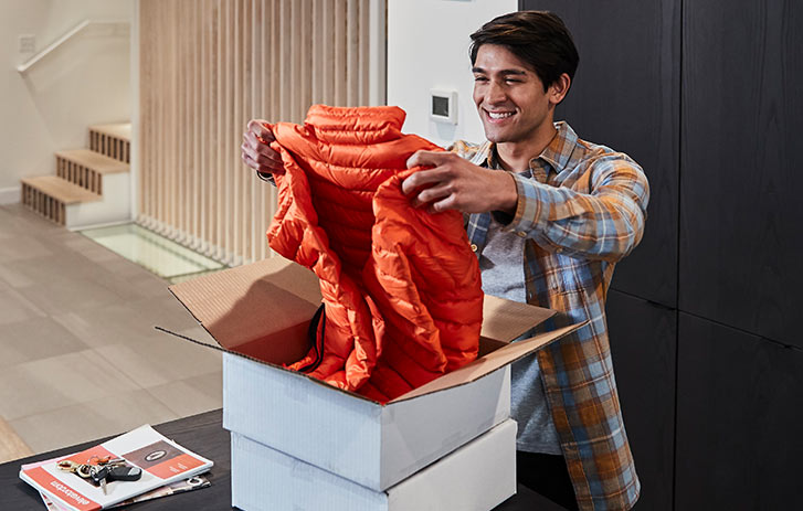 man unpacking new coat