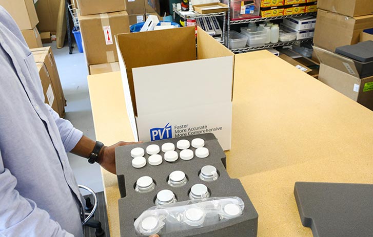 A photo of a man packing Phigenics products in custom-cut foam