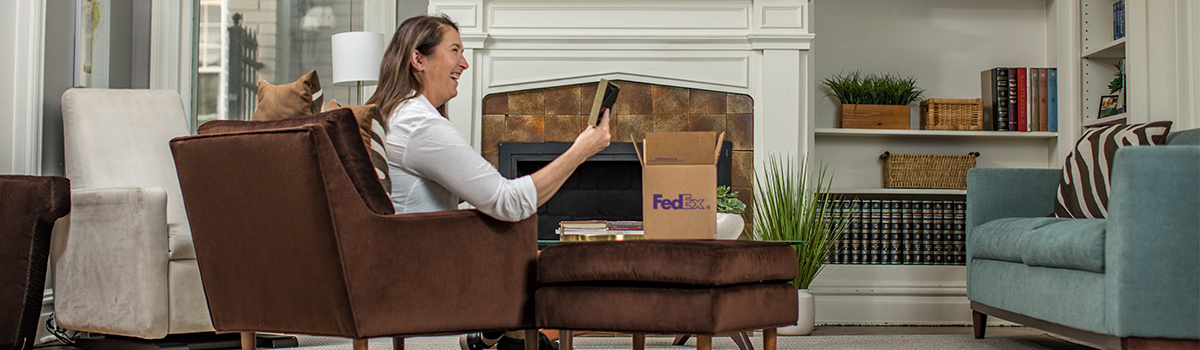 Woman holding a picture frame and smiling.