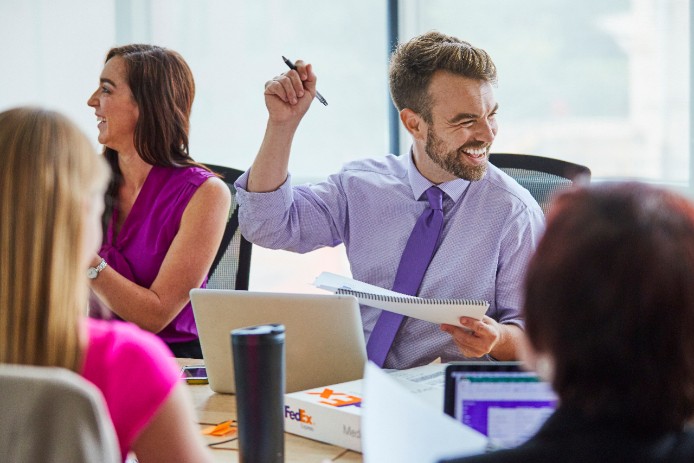 Hombre sonriendo en una reunión de negocios. 