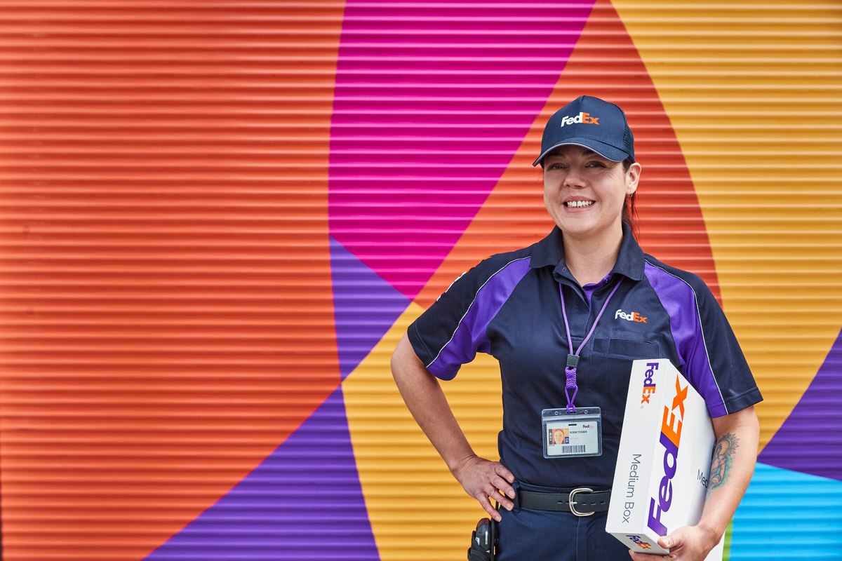 A FedEx team member holding a package.