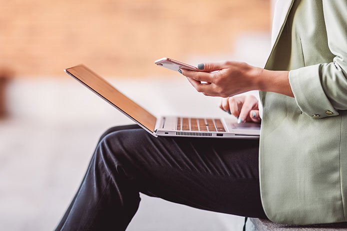 Woman on a laptop and mobile phone. 