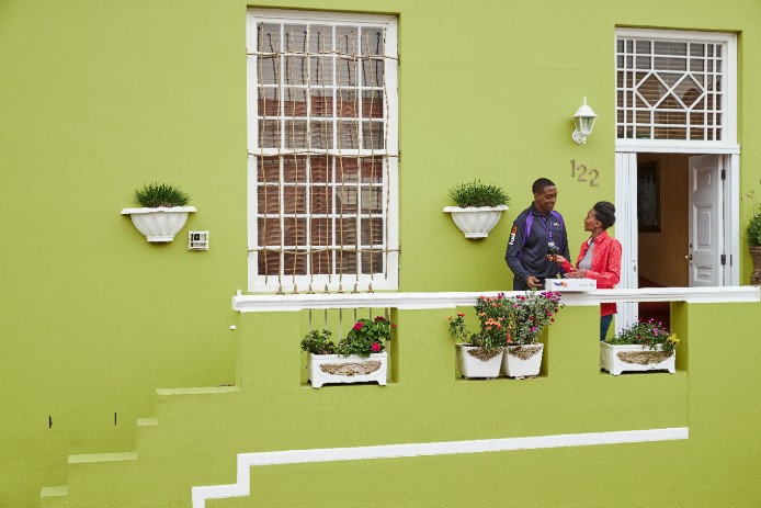 Courier and customer on a green building background. 