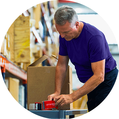 Man packing a box in a warehouse.