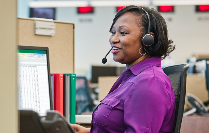 smiling woman wearing a headset in an office setting