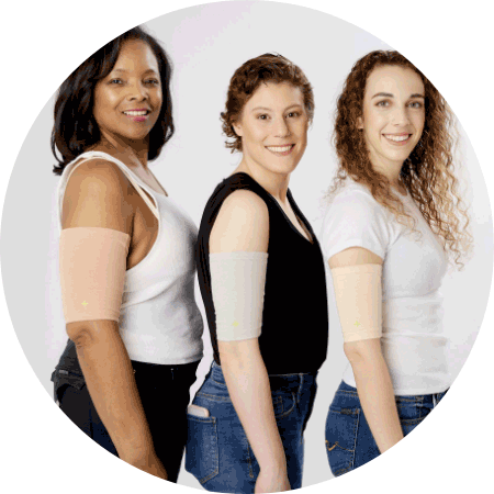 Three women standing close together in front of a white background