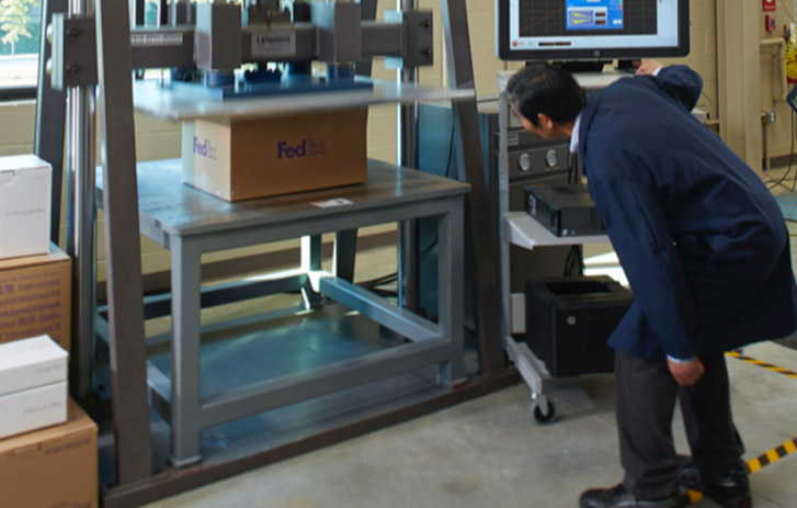 Packaging Lab Engineer testing a brown box.