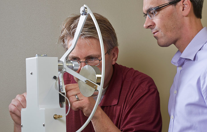 Two FedEx Packaging Lab Engineers using measurement equipment.