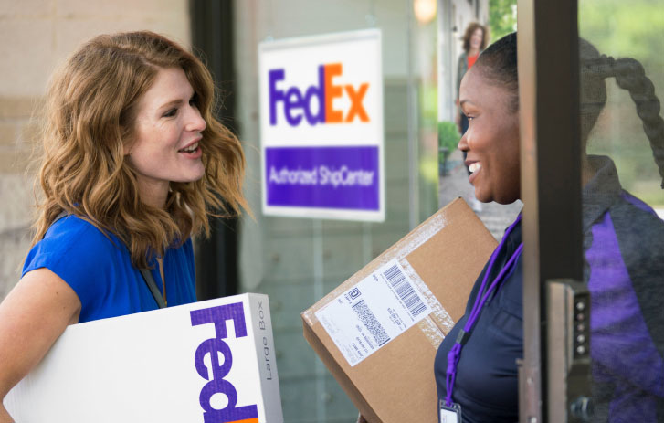 FedEx courier talking to a customer outside an FASC 