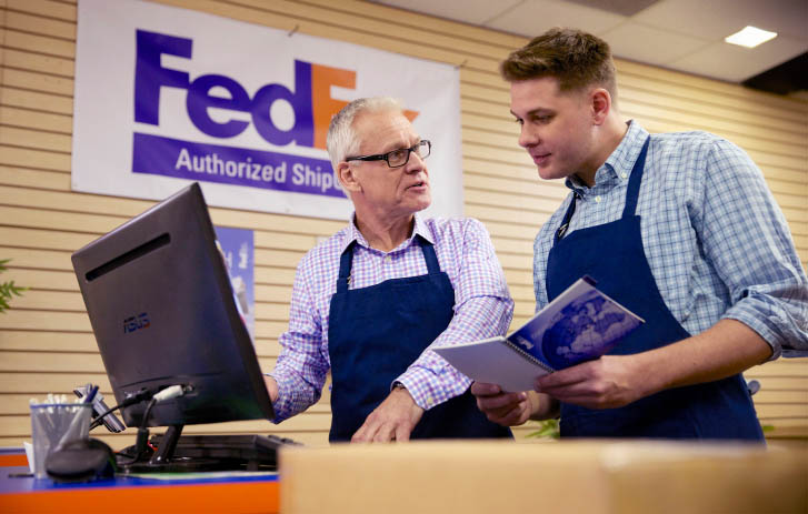 Two men looking at a computer monitor.