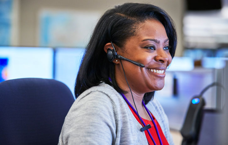 A woman smiling while wearing a headset.