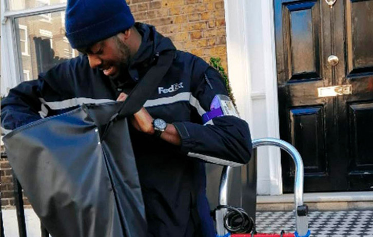 mensajero de FedEx mirando dentro de una bolsa