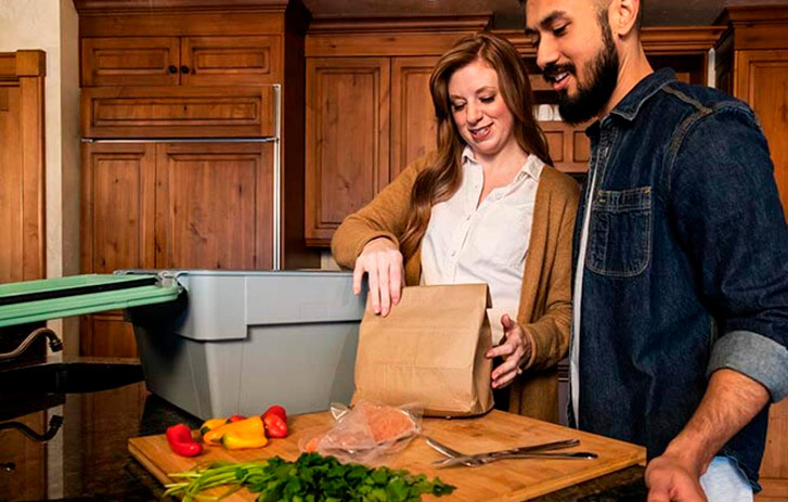 Pareja en la cocina abriendo una caja de embalaje de Liviri